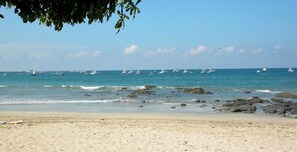 A beach with clear skies, calm sea, and boats. - Three bedroom  in Costa Rica, Playa Langosta (Tamarindo)
