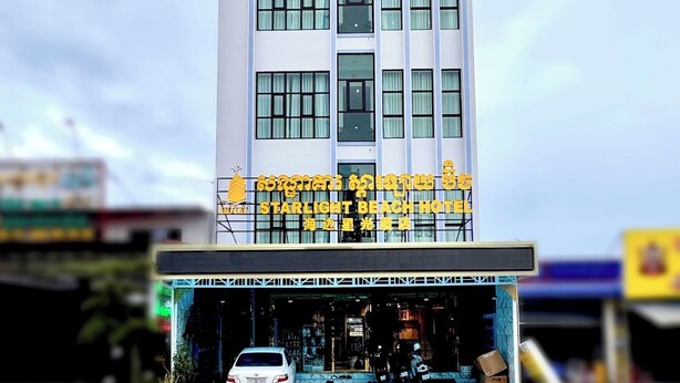 A multi-story hotel building with a modern facade, large windows, and a sign indicating it is the Starlight Beach Hotel.