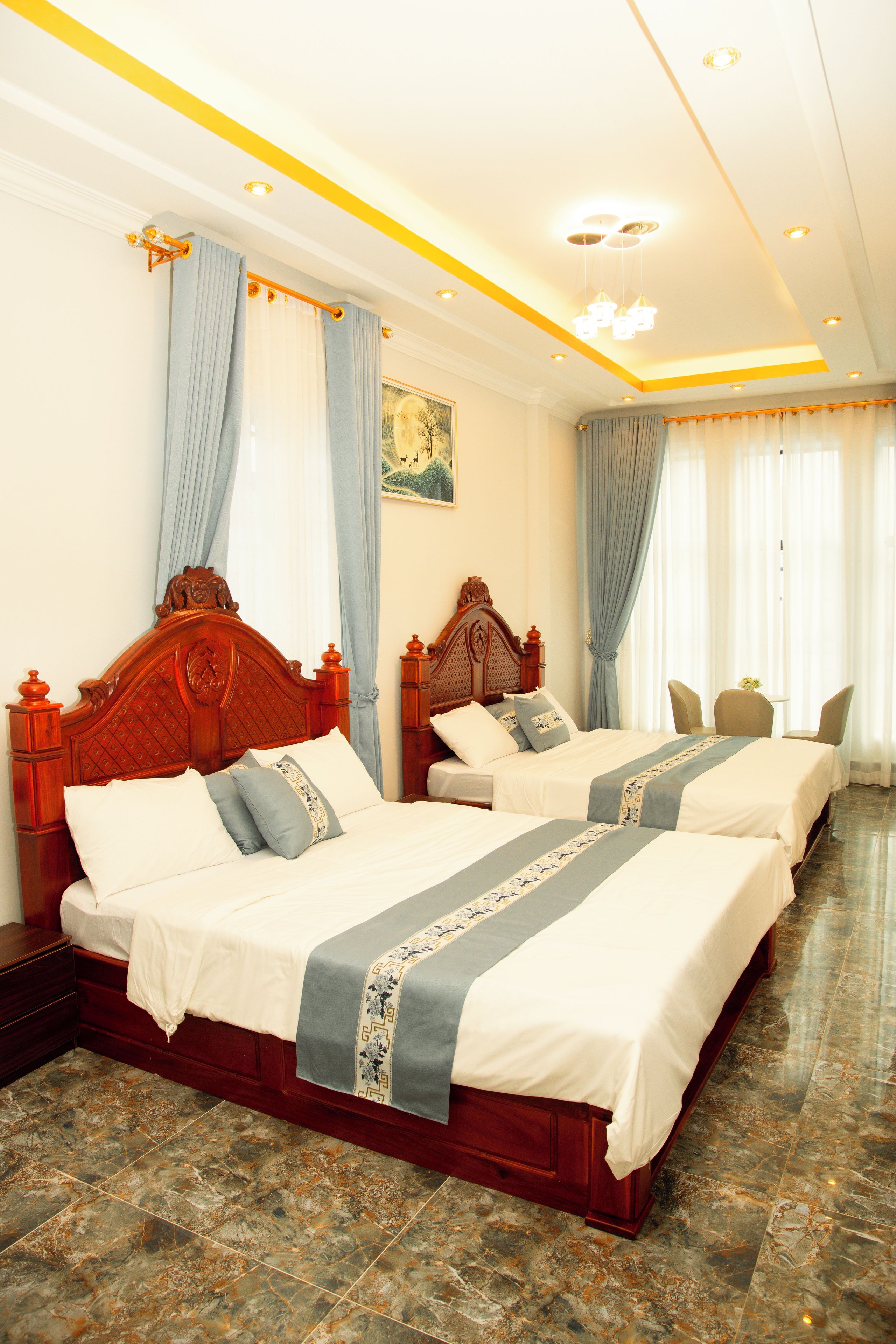 A hotel room with two wooden beds, a marble floor, and a painting on the wall.