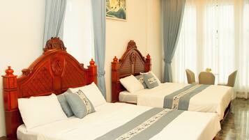 A hotel room with two wooden beds, a marble floor, and a painting on the wall.
