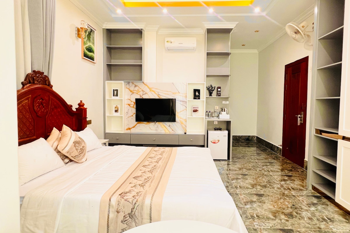 A hotel room with a bed, a television, a desk, and a wardrobe.