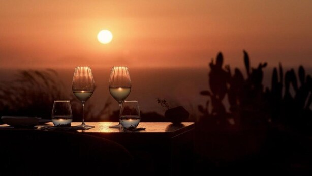 A sunset with three glasses of wine on a table. - Villa Lythion, Divine Sea Views, Private Pool, Furnished Terrace, Sanrotini (Oia, Santorini)