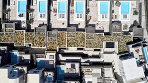 Ein Wohngebiet mit mehreren Häusern, die jeweils einen Swimmingpool und einen Garten haben.