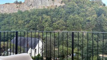 A balcony with a view of a mountain and a house.