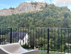 Ein Balkon mit Blick auf einen Berg und ein Haus.