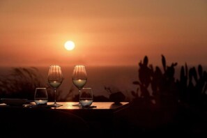 A sunset with three glasses of wine on a table. - Villa Elythiona, Divine Sea Views, Private Pool, Furnished Terrace, Sanrotini (Oia, Santorini)