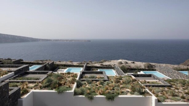 Área de piscina no terraço com várias piscinas e vista para o mar.