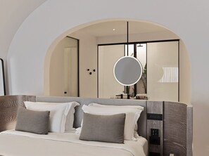 Ein modernes Hotelzimmer mit einem großen Bett, einem runden Spiegel und einer integrierten Bedienkonsole.