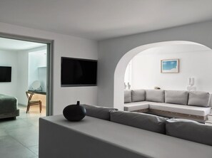 Una sala de estar moderna con un sofá, un televisor de pantalla plana y una decoración minimalista.