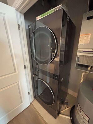 A compact, modern kitchen with a built-in dishwasher and a small refrigerator. - Modern 1BR Bridge Park in Dublin with Balcony and Pool (Dublin)