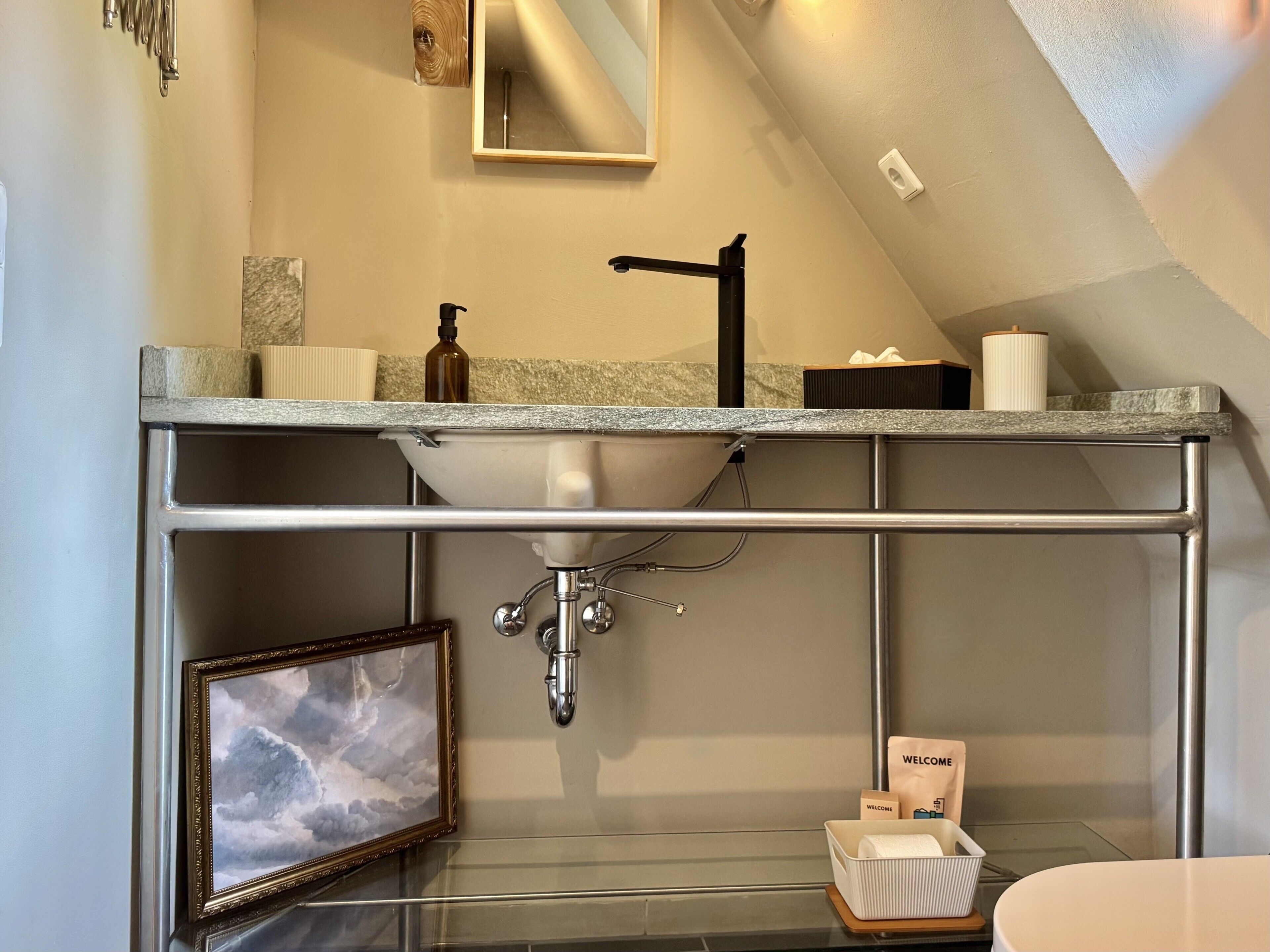 Een moderne badkamer met een ingebouwd wastafelmeubel, een inlijsting foto en een welkomstpakket.