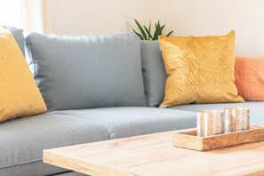 A modern living room with a grey sofa, a wooden coffee table, and decorative items. - Mulhouse by Hardt (Mulhouse)