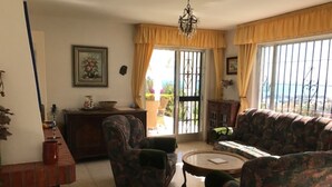 Ein Wohnzimmer mit zwei gemusterten Sofas, einem kleinen runden Tisch und einem Kamin.