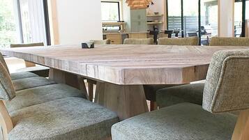 Un comedor moderno con una gran mesa de madera y sillas tapizadas.
