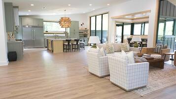 Amplia sala de estar con cocina, comedor y asientos con vistas.