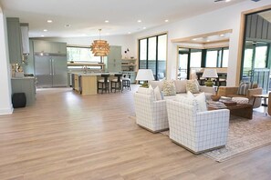 Amplia sala de estar con cocina, comedor y asientos con vistas.