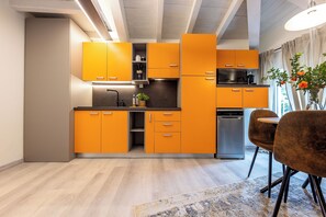 A modern kitchen with orange cabinets, a microwave, and a dishwasher. - La Mansarda in Oltretorrente, a cozy retreat among the rooftops of Parma (Parma)