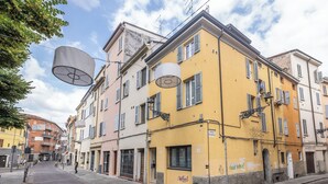 A street view with multi-story buildings, a clear sky, and pedestrians. - La Mansarda in Oltretorrente, a cozy retreat among the rooftops of Parma (Parma)