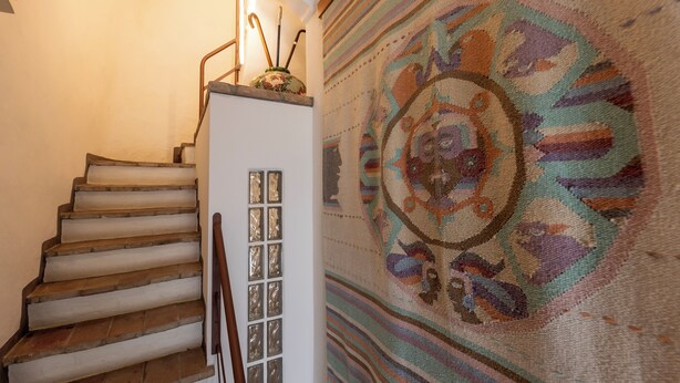 A staircase with a handrail and a patterned carpet. - La Mansarda in Oltretorrente, a cozy retreat among the rooftops of Parma (Parma)