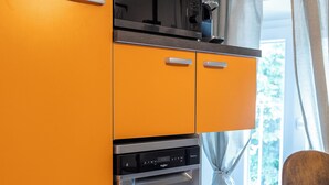 A compact kitchen with a microwave, oven, and a small refrigerator. - La Mansarda in Oltretorrente, a cozy retreat among the rooftops of Parma (Parma)