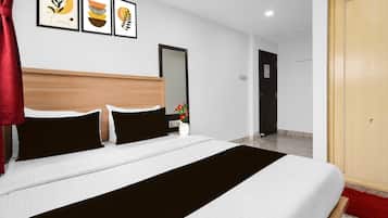 Habitación de hotel con cama, espejo, puerta y decoración en la pared.