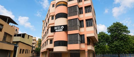 Un edificio de hotel de varios pisos con un letrero que indica que cuenta con servicios de OYO.