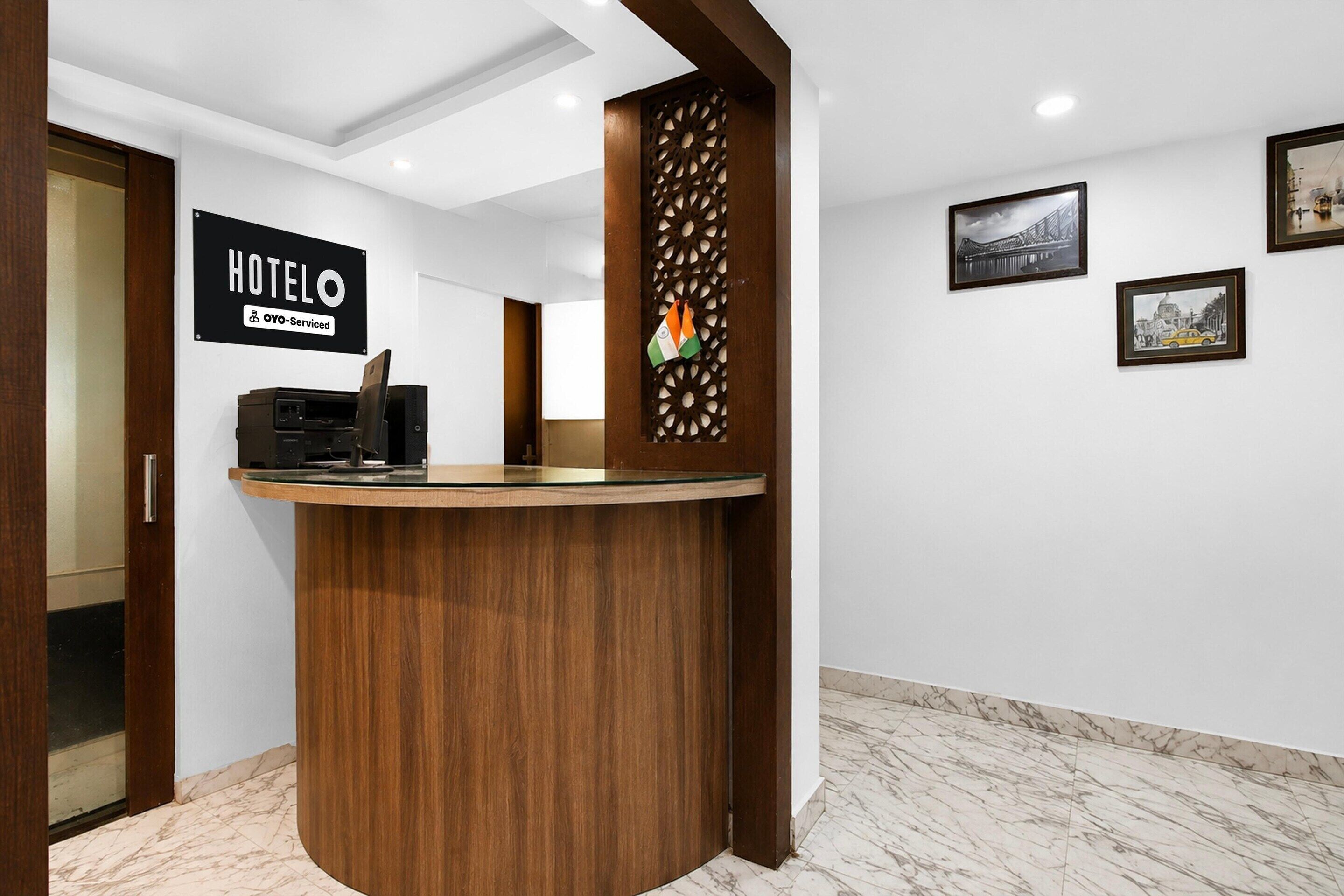 A hotel reception desk with a sign indicating it is serviced by OYO.