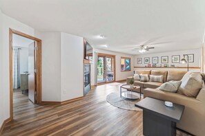 A modern living room with a sofa, coffee table, and a flat-screen TV.