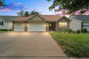 A two-story house with a garage, a front porch, and a driveway.