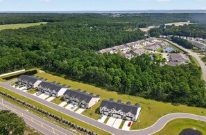A residential area with multiple houses, a parking lot, and a road.