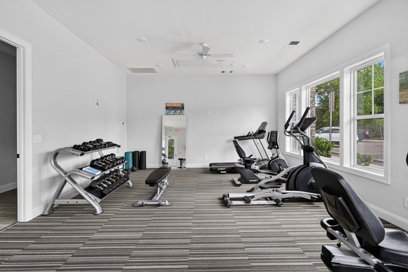 A gym with treadmills, elliptical machines, and free weights.