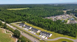 A large residential complex with multiple houses and a central parking area. - Sea La Vie at OIB | Townhome Near Golf & Beaches (Ocean Isle Beach)