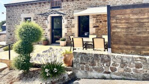 A stone building with a patio area, outdoor seating, and a small garden. - Les Pierres de Lamballe – Countryside near beaches (Lamballe)