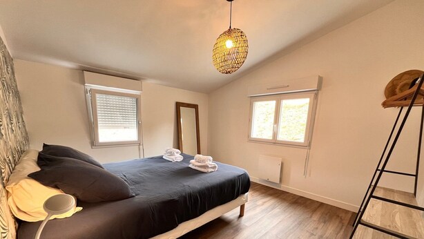 A bedroom with a bed, bedside table, lamp, windows, and a ladder. - Les Pierres de Lamballe – Countryside near beaches (Lamballe)