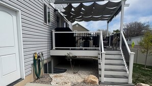 A residential property with a covered outdoor area, a staircase, and a driveway with gravel and rocks. - Family and pet friendly 5-bedroom home in charming Clearfield (Clearfield)