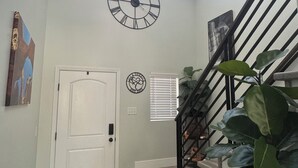 A staircase with a black railing, a white door, and a large plant on the landing. - Family and pet friendly 5-bedroom home in charming Clearfield (Clearfield)