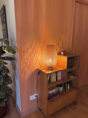 A wooden bookshelf with a textured lamp on top, a potted plant to the left, and a wall with a chalkboard menu. - A Cottage Amid the Birdsong. Beautiful views and tranquility, 300 meters from Flow Vélo (Chazelles)