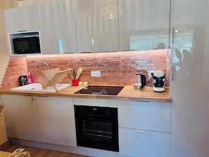 A kitchen with a microwave, coffee maker, and dishwasher. - A Cottage Amid the Birdsong. Beautiful views and tranquility, 300 meters from Flow Vélo (Chazelles)