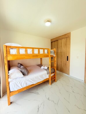 A bunk bed with a wooden frame, white bedding, and a ladder. - NEW Pool Villa, 3 Min to Downtown, Sleeps 8 (Punta Cana)
