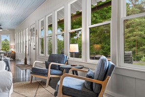 A room with large windows, a wooden ceiling, and a seating area with two chairs and a table. - Belclare - Vineyard Estate (Northport)
