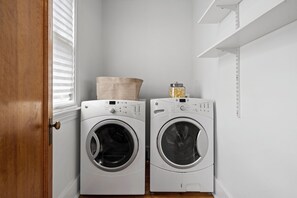 A laundry room with two front-loading washing machines and a drying rack. - Belclare - Vineyard Estate (Northport)