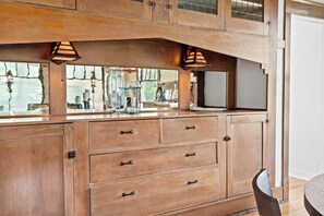 A wooden kitchen with a built-in stove, cabinets, and a hanging light fixture. - Belclare - Vineyard Estate (Northport)