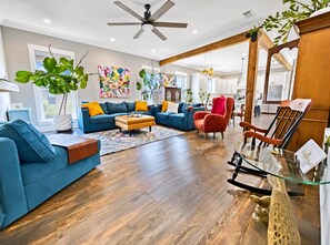 Ein modernes Wohnzimmer mit einem blauen Sofagarnitur, einem Holztisch und einem roten Sessel.