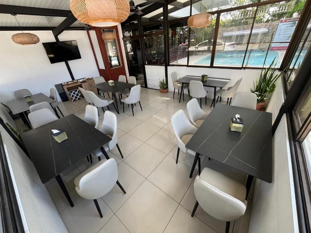 A restaurant with outdoor seating, a pool view, and a flat-screen TV.