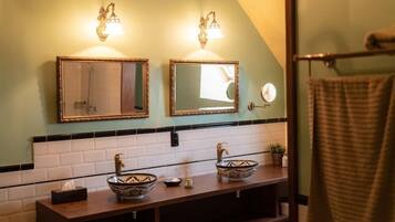 Casa de banho com duas pias, um porta-toalhas e um espelho.
