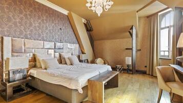 Une chambre à coucher avec un grand lit, des tables de chevet, un bureau et une chaise.