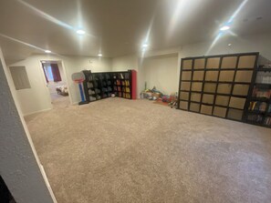 A room with a carpeted floor, a bookshelf, a door, and a basketball hoop. - Private Boulder Guest Suite with Kitchen, Near Trails & Downtown (Boulder)