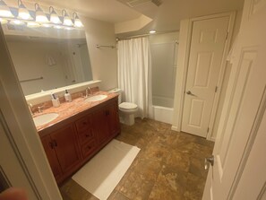 A bathroom with a double sink vanity, a toilet, a shower with a glass door, and a white door. - Private Boulder Guest Suite with Kitchen, Near Trails & Downtown (Boulder)