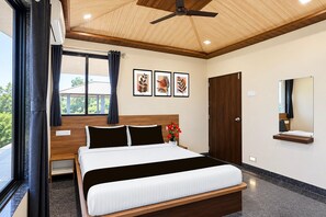 A modern bedroom with a bed, a ceiling fan, a window with curtains, and a wall-mounted mirror.