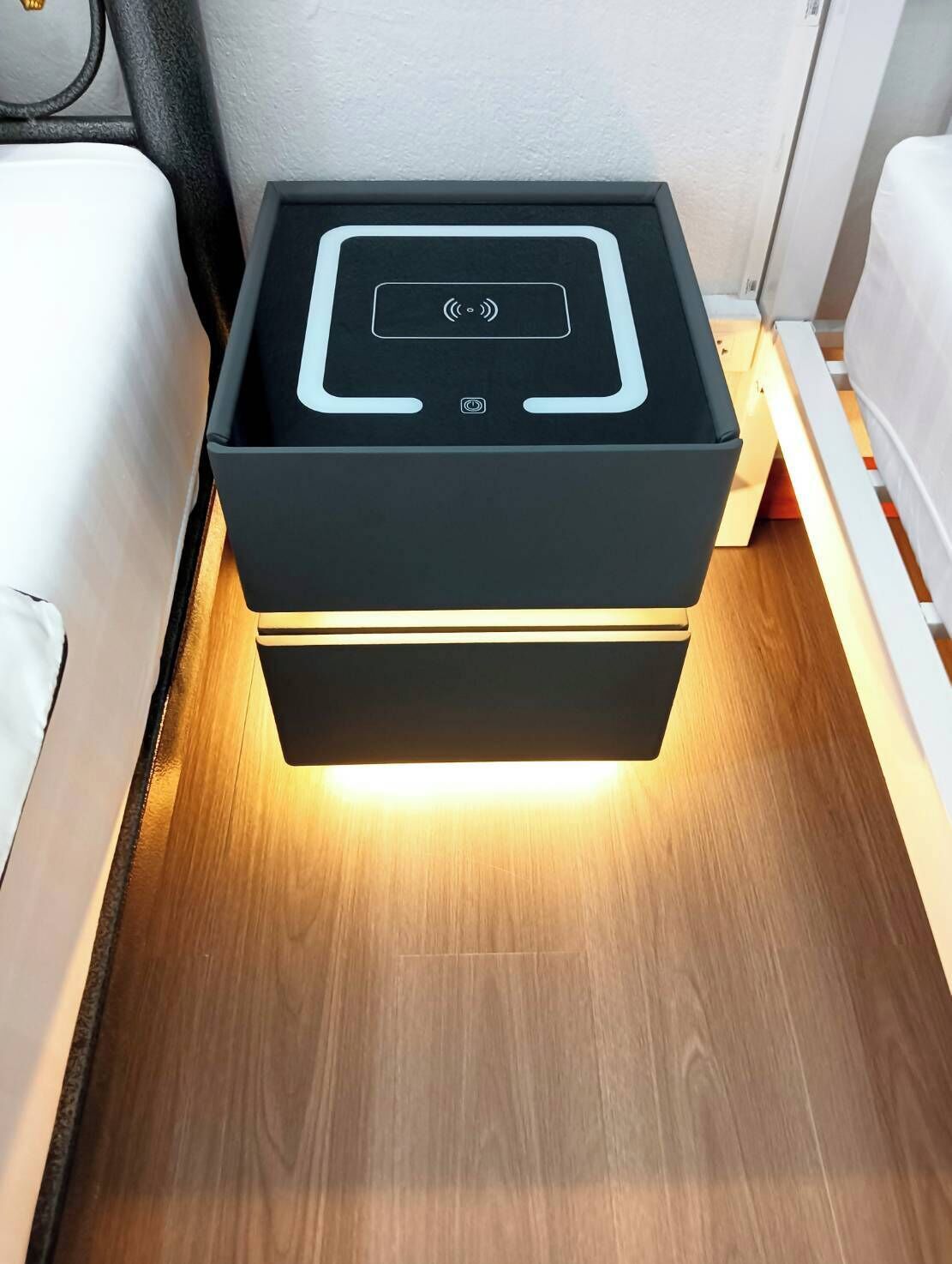 Une table de chevet dotée d’une station de recharge intégrée et d’un bouton d’alimentation.